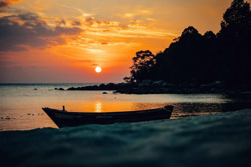 Longtail boat on the shore at sunset