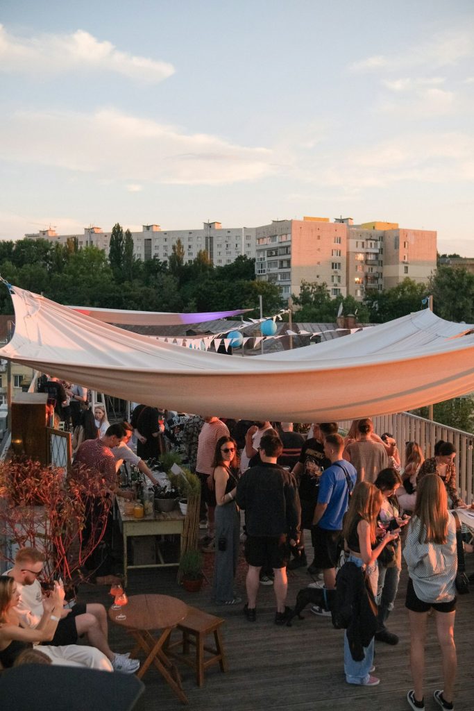 Crowd dancing on a wooden deck under a canopy