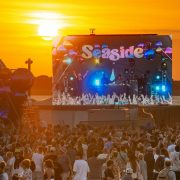 Outdoor music festival crowd at sunset